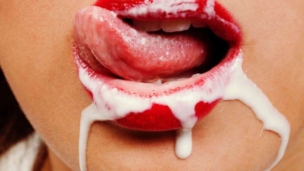 bocca di donna che lecca latte intorno alle proprie labbra