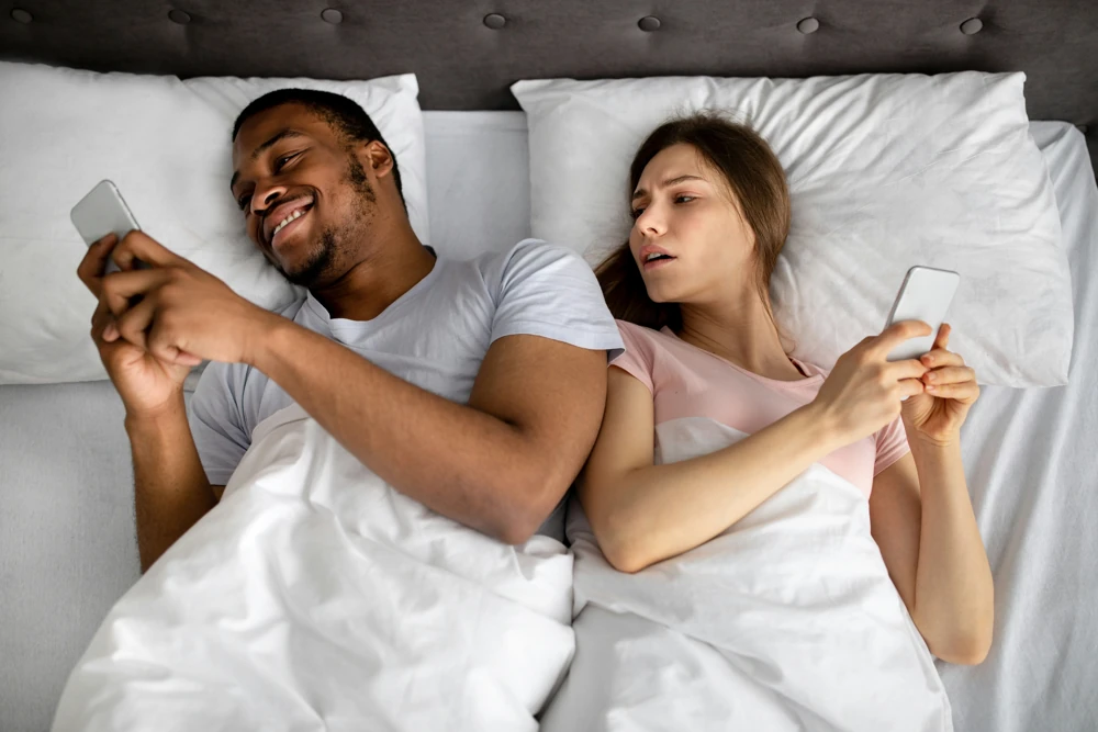 coppia smartphone a letto